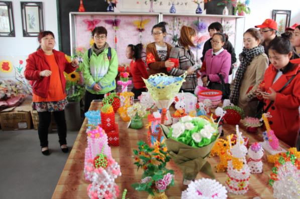 幸平阳光家园老师丁旭（左一）讲述孩子们制作串珠的不易.png